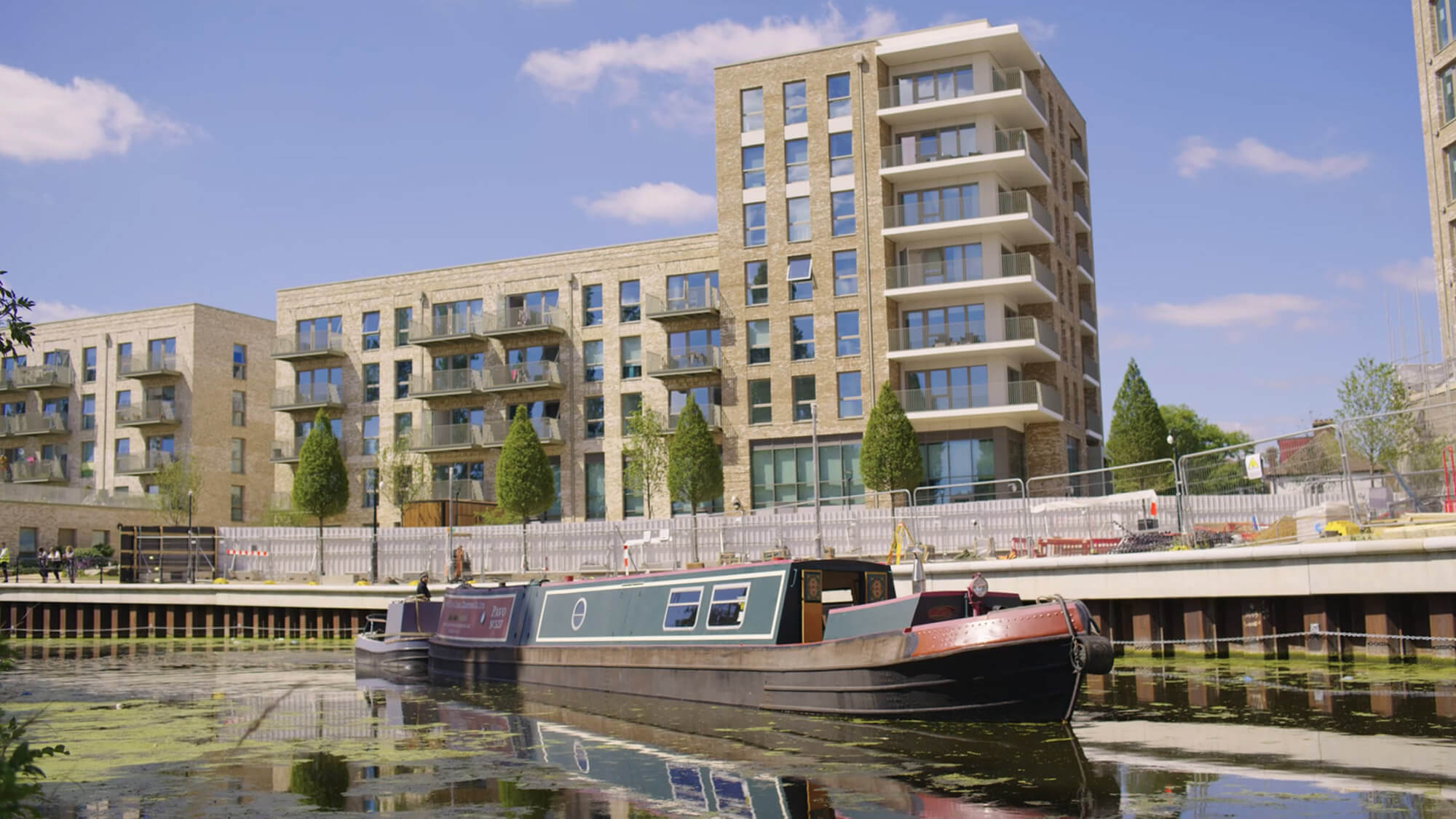 Still image from a real estate video of Berkeley Homes new canal-side property development, next to PAVO, an historic narrowboat