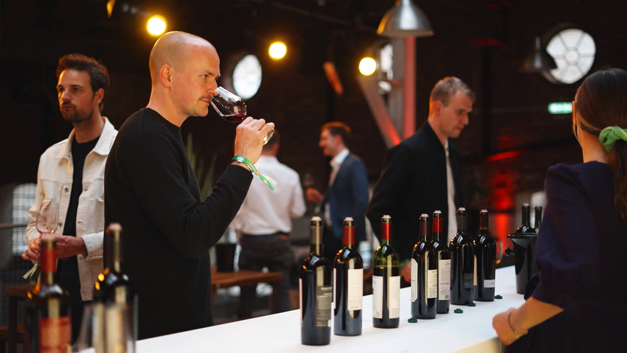 An event attendee tasting a glass of wine at a live event