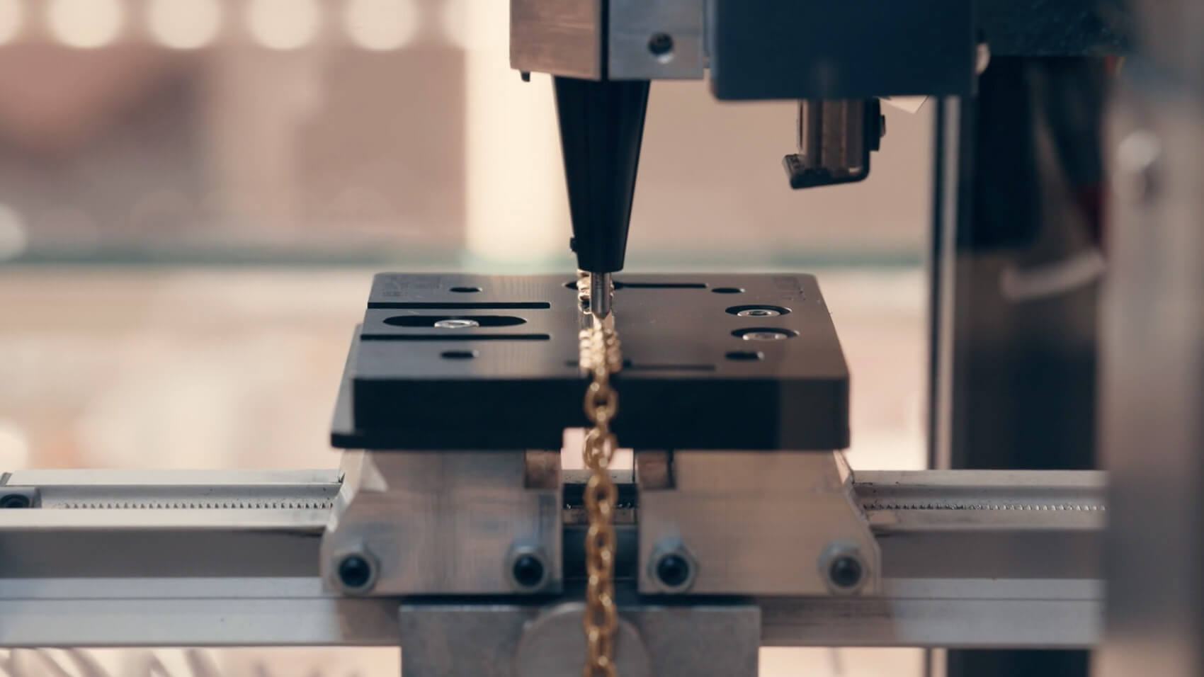 An engraving machine being used to create a design on a gold necklace