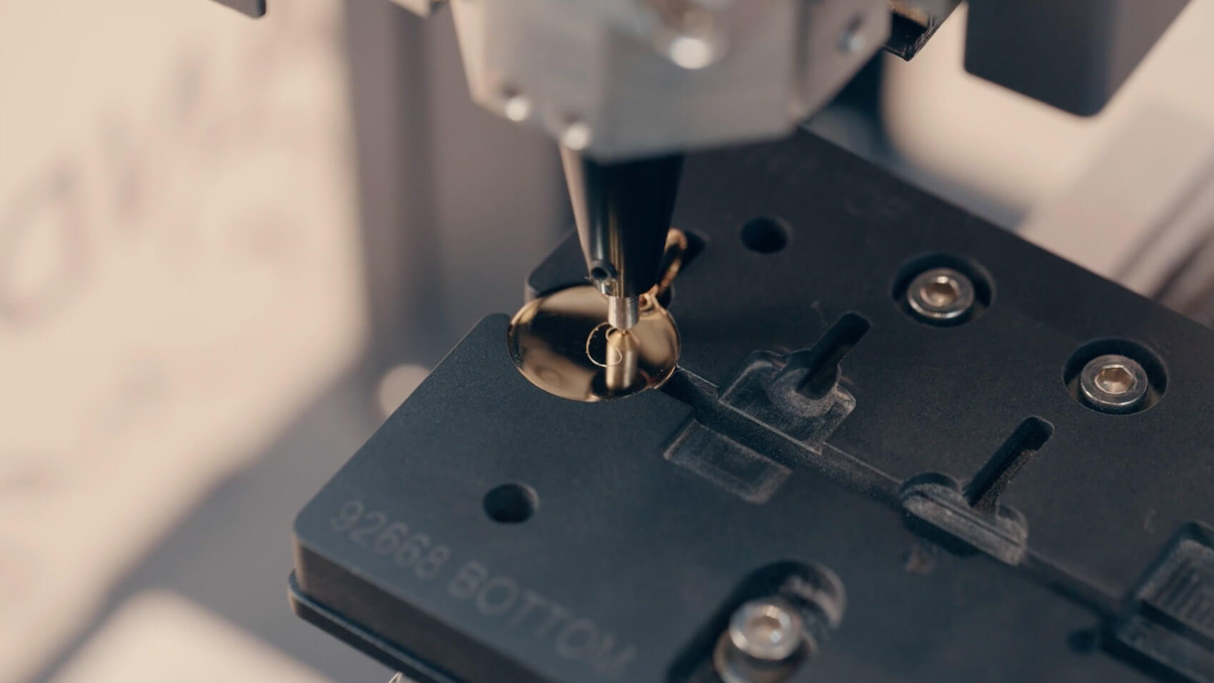 An engraving machine creating a design on a necklace