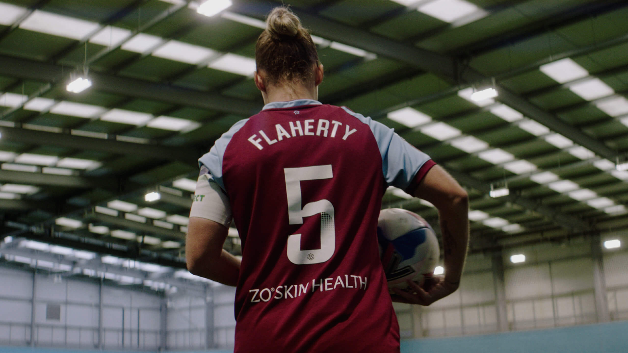 Gilly Flaherty walking onto a training pitch holding a football in an Ezra West Ham Women partnership film project, from the Rise Media case studies archive